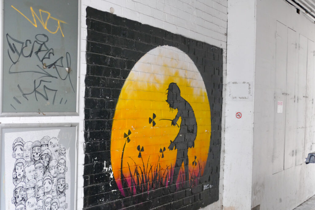 Murale con bambina che raccoglie fiori radioattivi